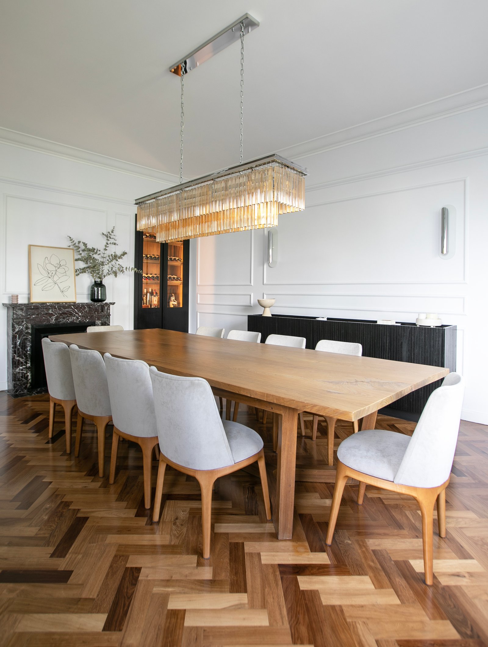 Sala de jantar elegante com mesa de madeira, cadeiras cinzas e lustre de cristal — projeto Lacroze, por Estudio Losa, em Belgrano